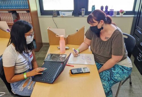 Brianna and Math teacher Sarah Caulkins work through an equation together.